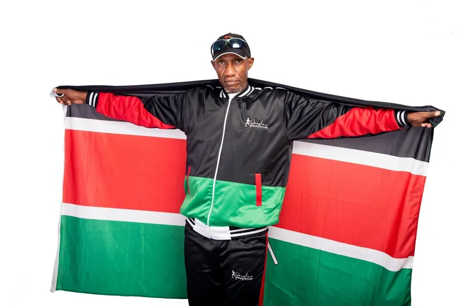 Douglas Wakiihuri spreading a Kenyan flag behind him like wings