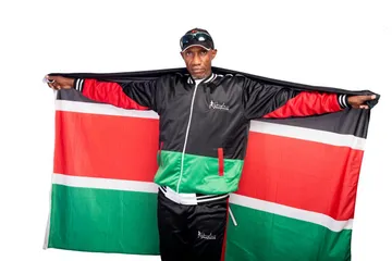 Douglas Wakiihuri spreading a Kenyan flag behind him like wings
