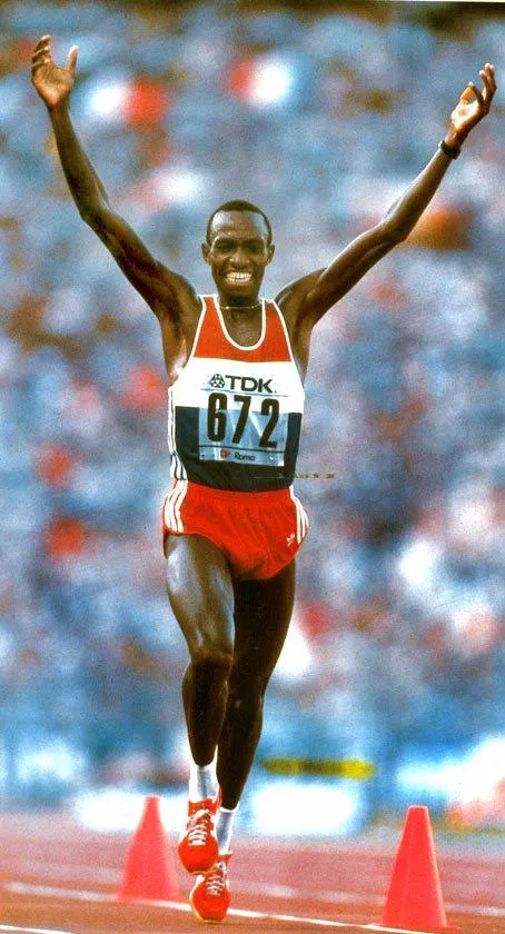 Douglas Wakiihuri crossing the line with both arms raised, bib 672, World Championships marathon, Rome 1987